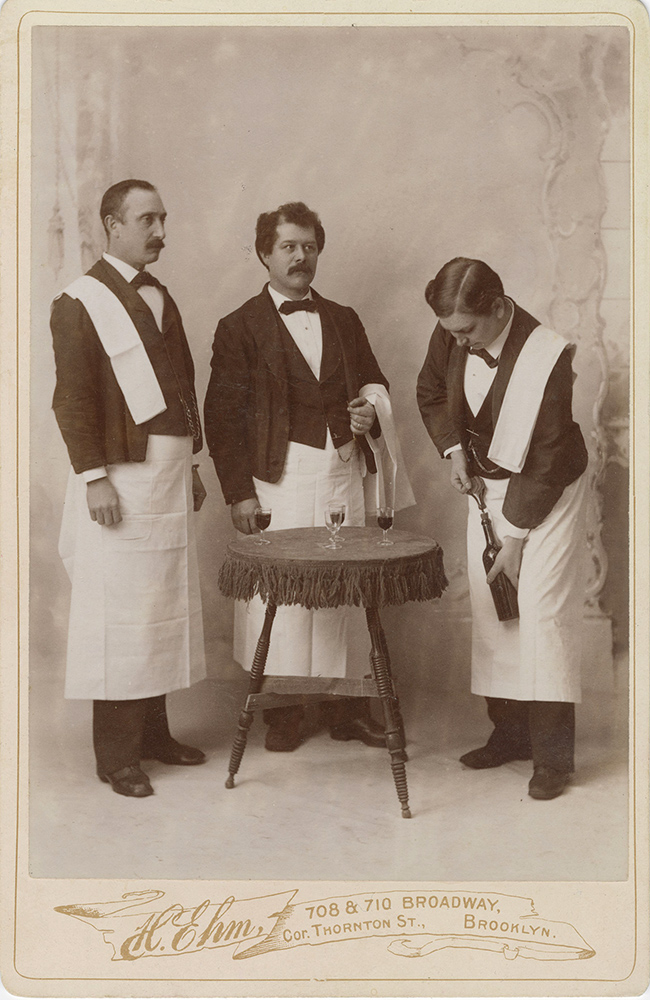 Henry Ehm - Waiters and Sommelier Opening a Bottle of Wine